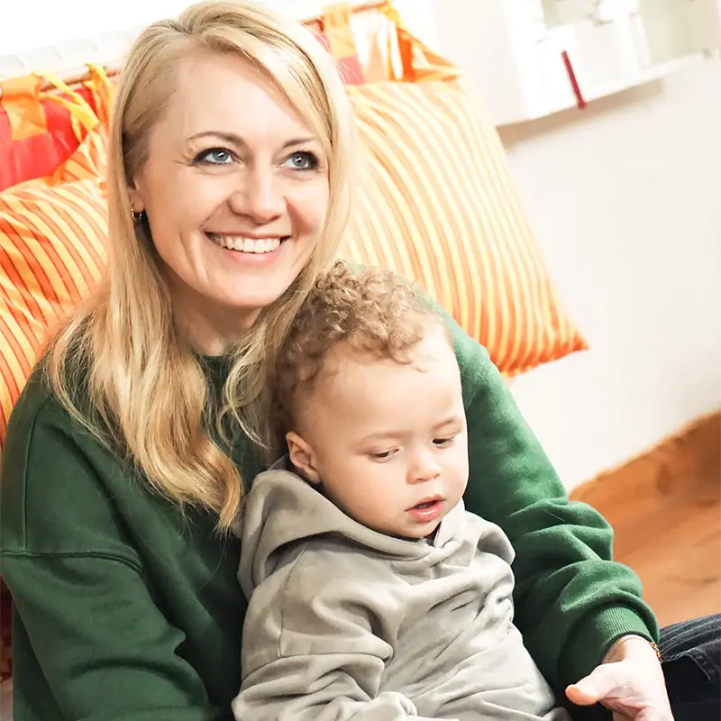 Lena mit Kind auf dem Arm schaut nach oben